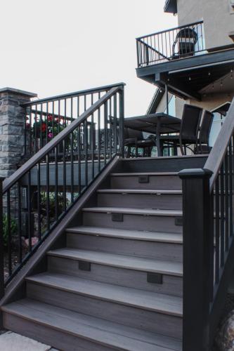 Back-Deck-Timbertech-Azek-Line-Custom-Steel-Railing-Stone-Veneer-Columns-Low-Volt-Lighting-Closed-Face-Stairs-Darian (1)