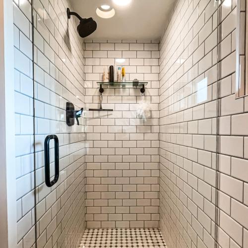 Bathroom-White-Subway-Shower-Tile-Dark-Grout-Glass-Shower-Door-Black-Finishes-Mosaic-Floor-Tile-Cherokee