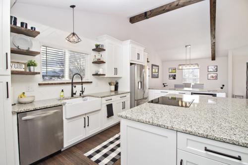 Copy-of-Open-Concept-Kitchen-Dining-White-Tile-Backsplash-Dark-Hardwood-Floor-Light-Grout-Wood-Beams-Granite-Countertop-White-Cabinets-Farmhouse-Stainless-Steel-Appliances-Floating-Wood-Shelves-Pendant-Light-War-Eagle