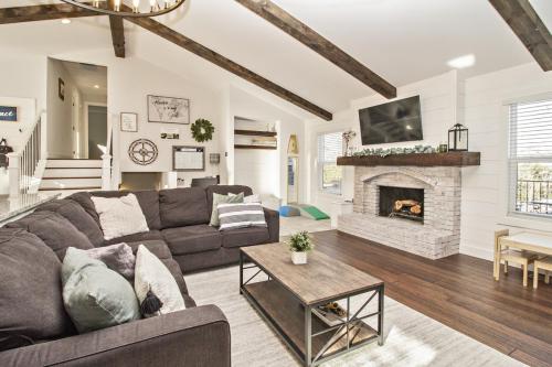 Copy-of-Open-Concept-Living-Area-White-Washed-Fireplace-Dark-Hardwood-Floor-Wood-Beams-White-Shiplap-Pendant-Lighting-Wood-Floating-Shelves-War-Eagle